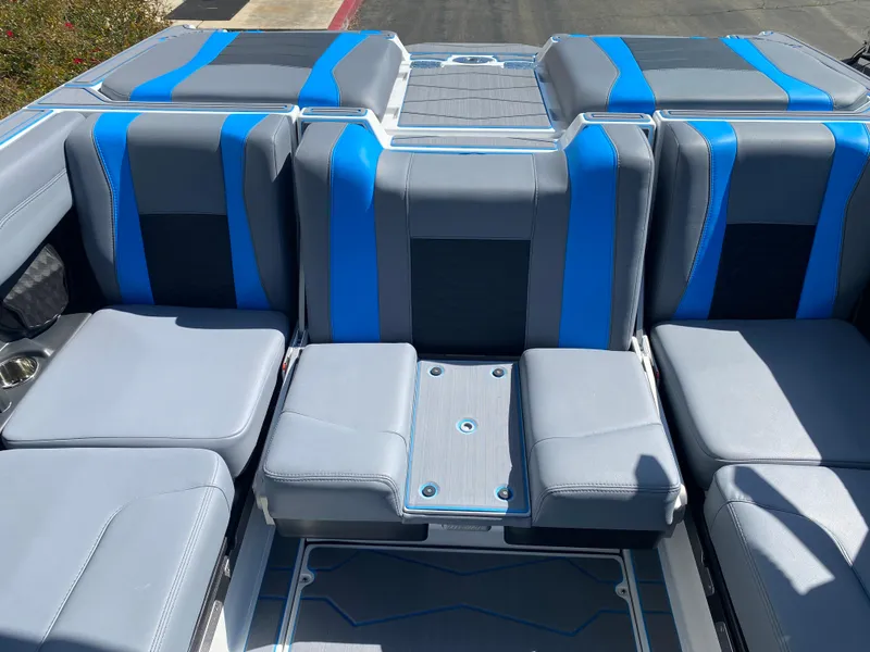 Slide: The Image of 2025 Malibu Wakesetter 23 MXZ interior seating with blue and gray upholstery. - 15