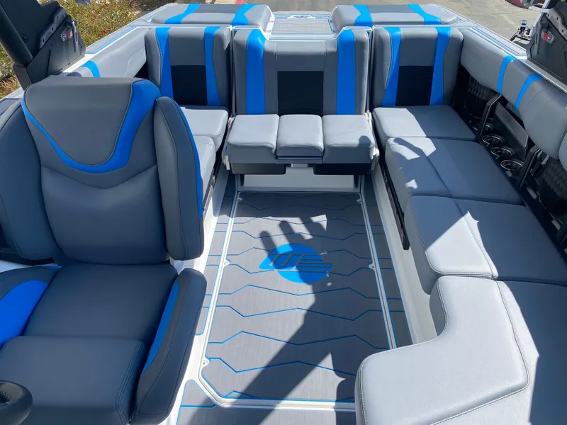 Slide: The Image of 2025 Malibu Wakesetter 23 MXZ interior with blue and gray seating, spacious layout. - 8