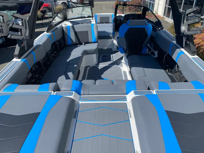 Slide: The Image of 2025 Malibu Wakesetter 23 MXZ interior with blue and gray seating, showcasing spacious design. - 9