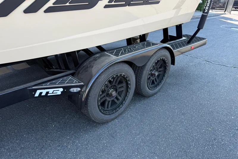 Slide: The Image of Trailer of MB B52 21 Alpha 2025 with dual black wheels on asphalt. - 11