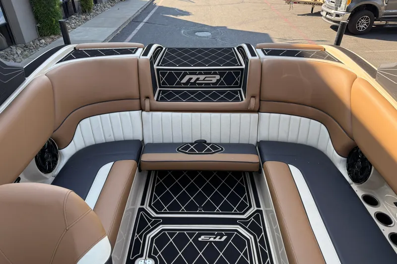 Slide: The Image of 2025 MB B52 21 Alpha boat interior with brown and white seating, black accents. - 19