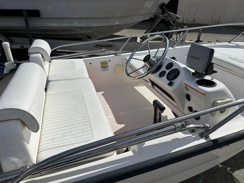 Slide: The Image of 2008 Boston Whaler 130 Sport boat interior with steering wheel and seating. - 10