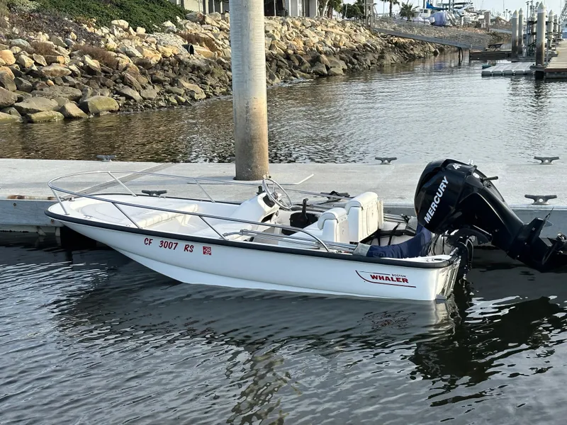 Slide: The Image of 2008 Boston Whaler 130 Sport boat docked with Mercury outboard motor. - 2