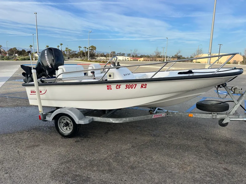 Slide: The Image of 2008 Boston Whaler 130 Sport boat on trailer, parked outdoors. - 3