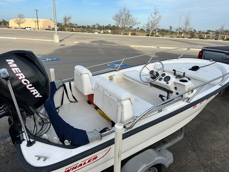 Slide: The Image of 2008 Boston Whaler 130 Sport boat with Mercury engine in parking lot. - 4