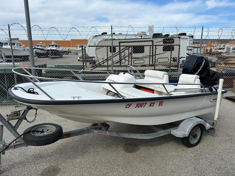 Slide: The Image of 2008 Boston Whaler 130 Sport boat on trailer, parked in a lot with RVs and boats. - 7