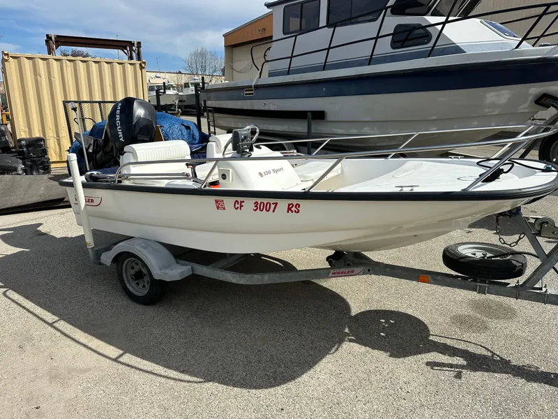 Slide: The Image of 2008 Boston Whaler 130 Sport boat on trailer, parked outdoors. - 8