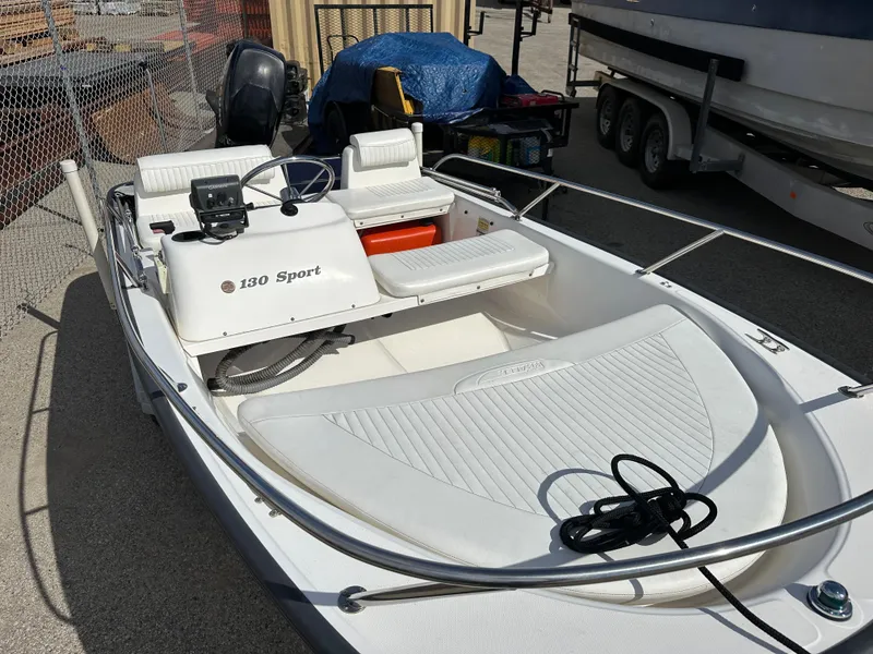 Slide: The Image of 2008 Boston Whaler 130 Sport boat, white interior, parked outdoors. - 9