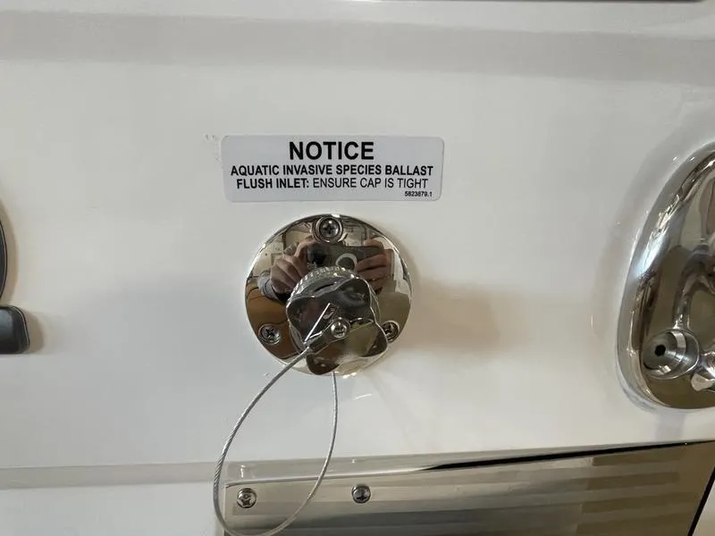 Slide: The Image of 2025 Malibu M230 ballast flush inlet with invasive species notice. - 10