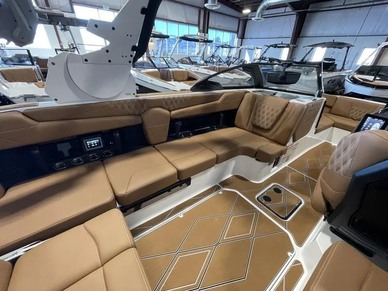 Slide: The Image of 2025 Malibu M230 boat interior with luxurious brown seating and modern design. - 12