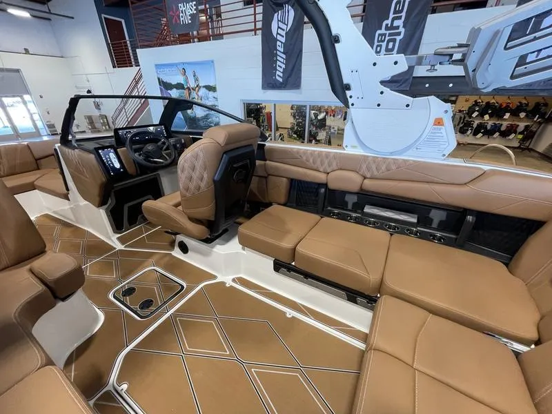 Slide: The Image of 2025 Malibu M230 boat interior with luxurious brown seating and modern dashboard. - 14