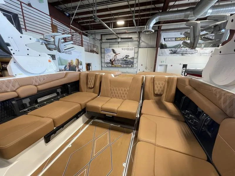 Slide: The Image of Luxurious interior of 2025 Malibu M230 boat with tan leather seating in showroom. - 15