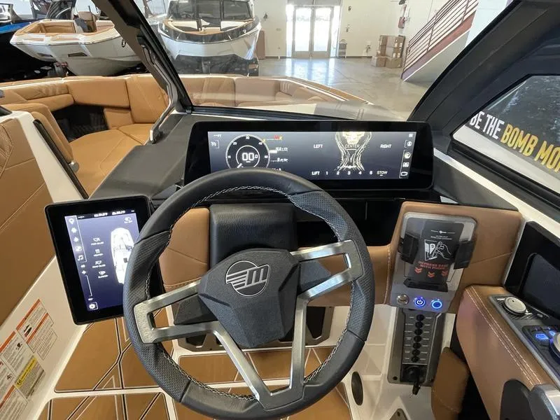 Slide: The Image of 2025 Malibu M230 boat dashboard with advanced digital controls and steering wheel. - 16