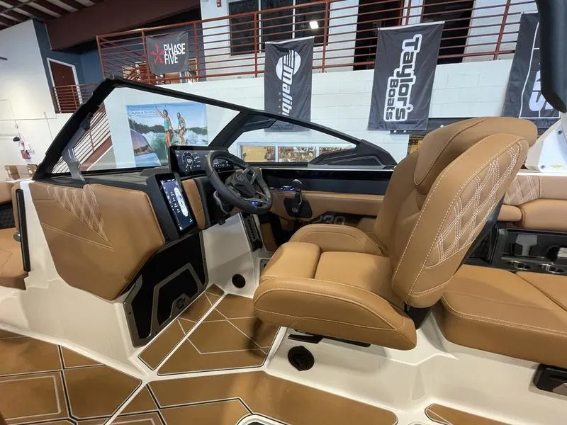 Slide: The Image of 2025 Malibu M230 boat interior with tan leather seats and modern dashboard. - 17