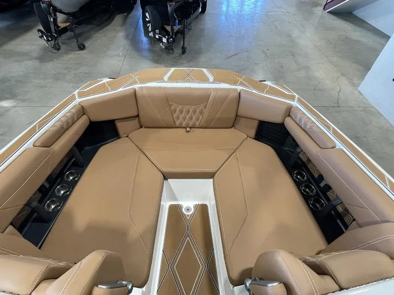Slide: The Image of 2025 Malibu M230 boat interior with tan leather seating and cup holders. - 18