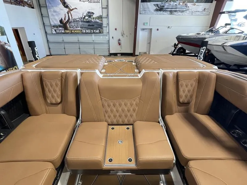 Slide: The Image of 2025 Malibu M230 boat interior with tan leather seating and modern design. - 23