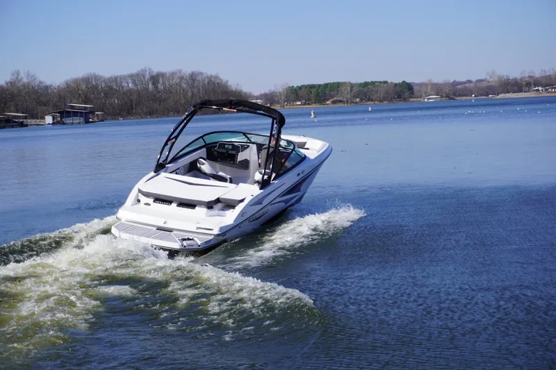 Slide: The Image of 2025 Monterey M22 boat cruising on a serene lake under a clear blue sky. - 5