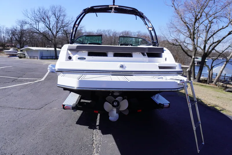 Slide: The Image of 2025 Monterey M22 boat, rear view, parked on asphalt near a lake. - 9