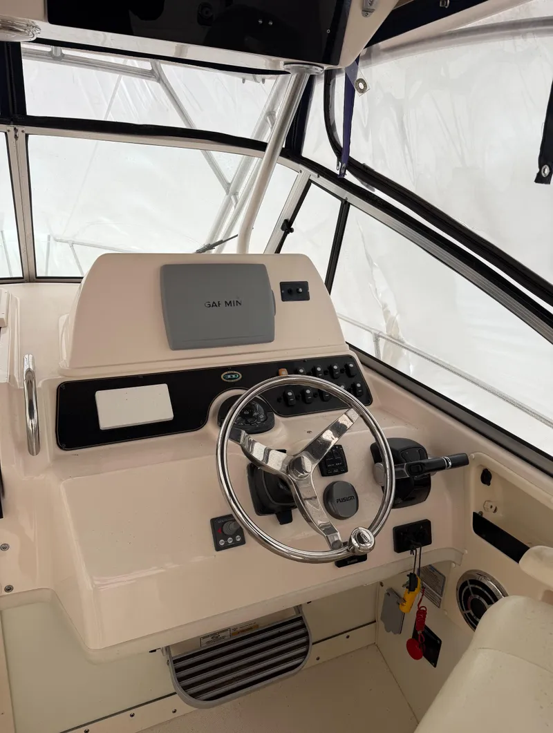Slide: The Image of 2013 Grady-White Marlin 300 boat helm with steering wheel and control panel. - 2