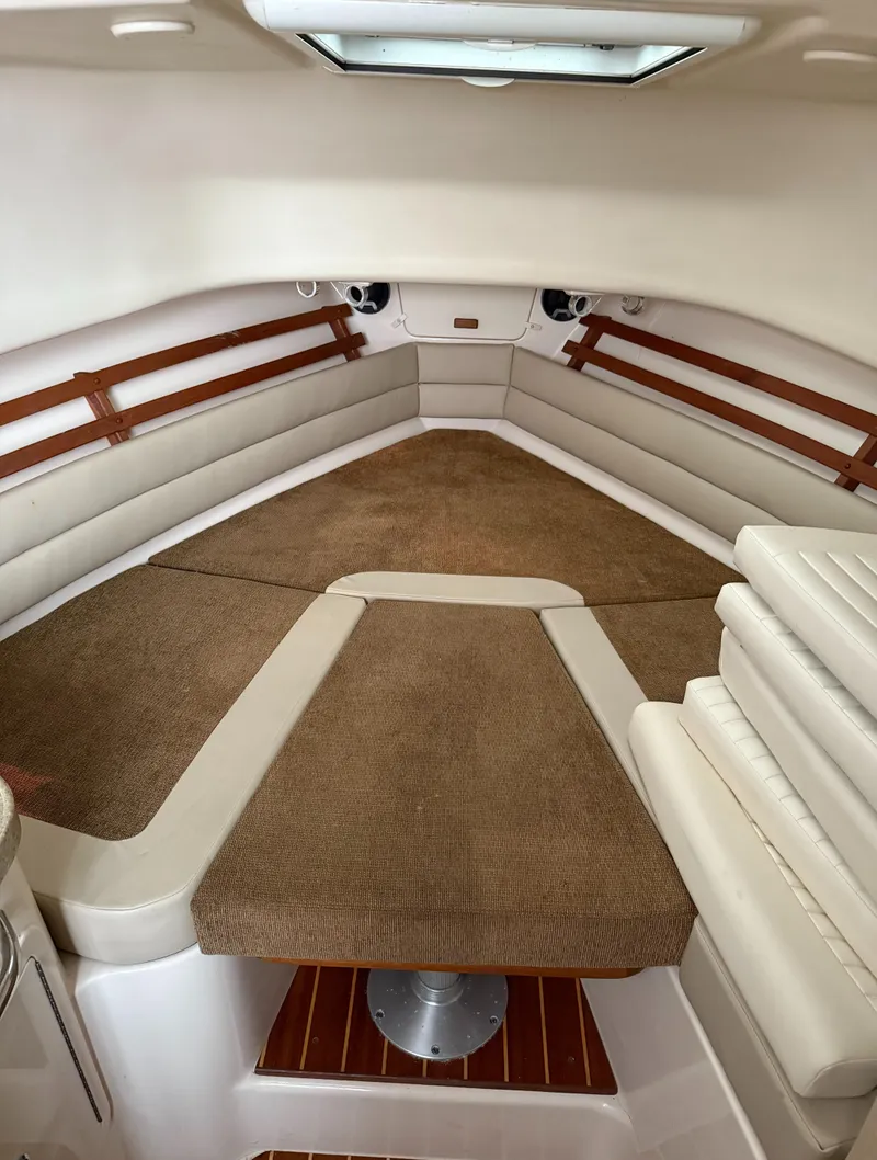 Slide: The Image of 2013 Grady-White Marlin 300 cabin interior with cushioned seating and wood accents. - 4