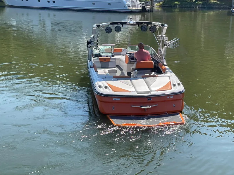 Slide: The Image of 2012 MasterCraft X45 boat on calm water, rear view, with a person onboard. - 3