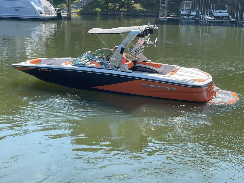 Slide: The Image of 2012 MasterCraft X45 boat on calm water, featuring orange and black design. - 4