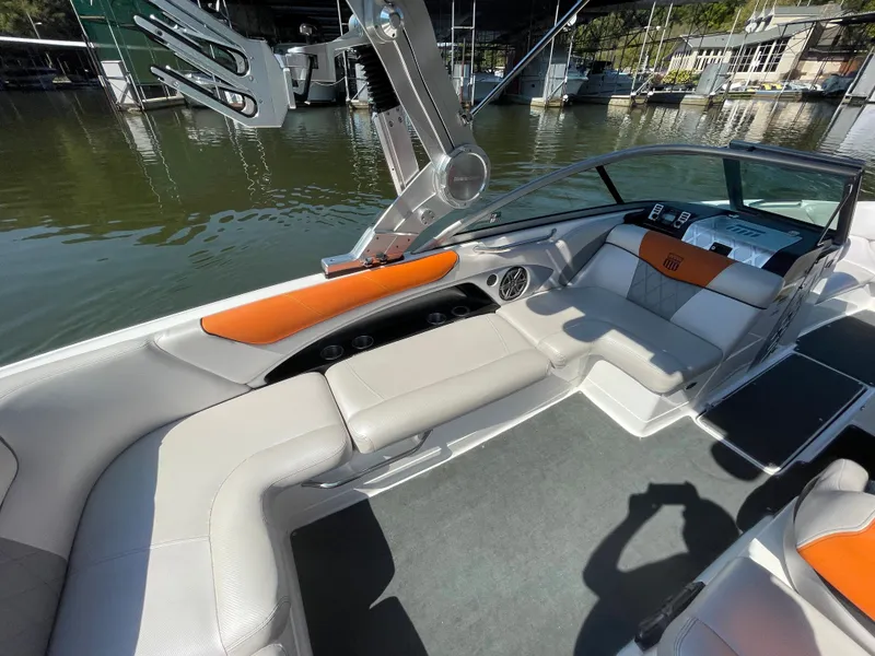 Slide: The Image of 2012 MasterCraft X45 boat interior with orange and white seating, docked by the water. - 7