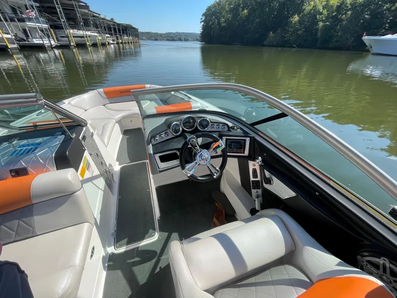 Slide: The Image of 2012 MasterCraft X45 boat interior with steering wheel, docked on a calm lake. - 8