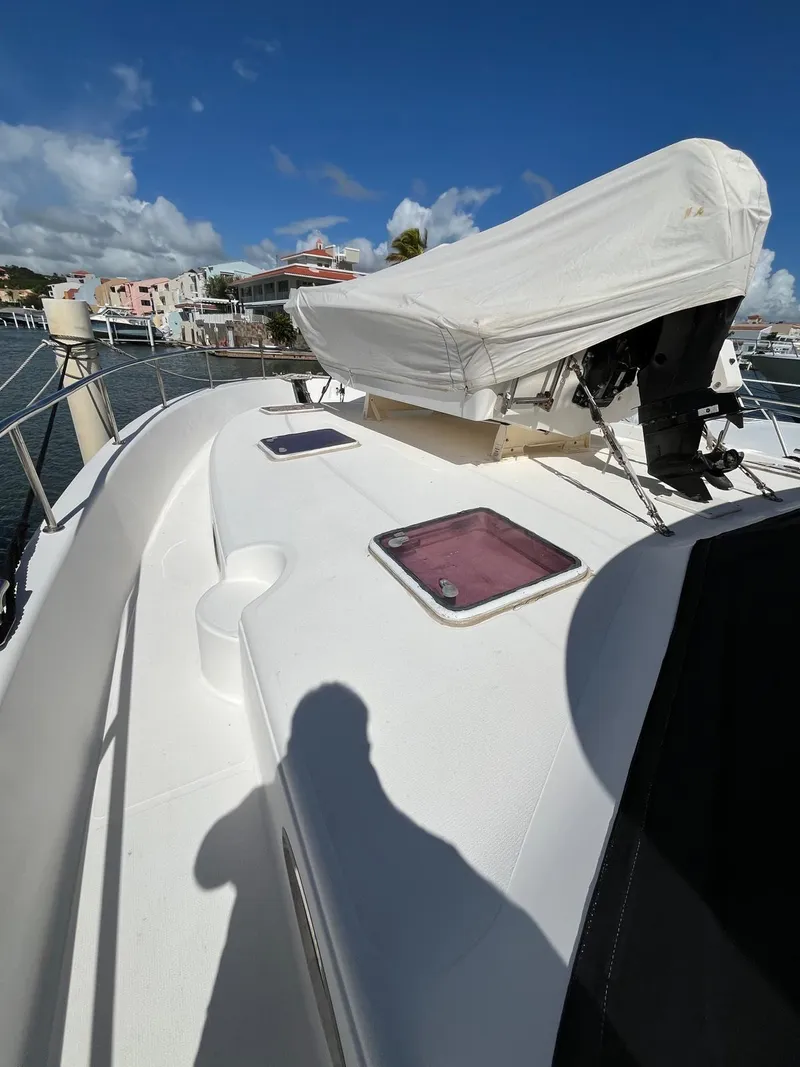 Slide: The Image of 2007 Maritimo M60 yacht deck with covered equipment, docked in a marina under blue skies. - 6
