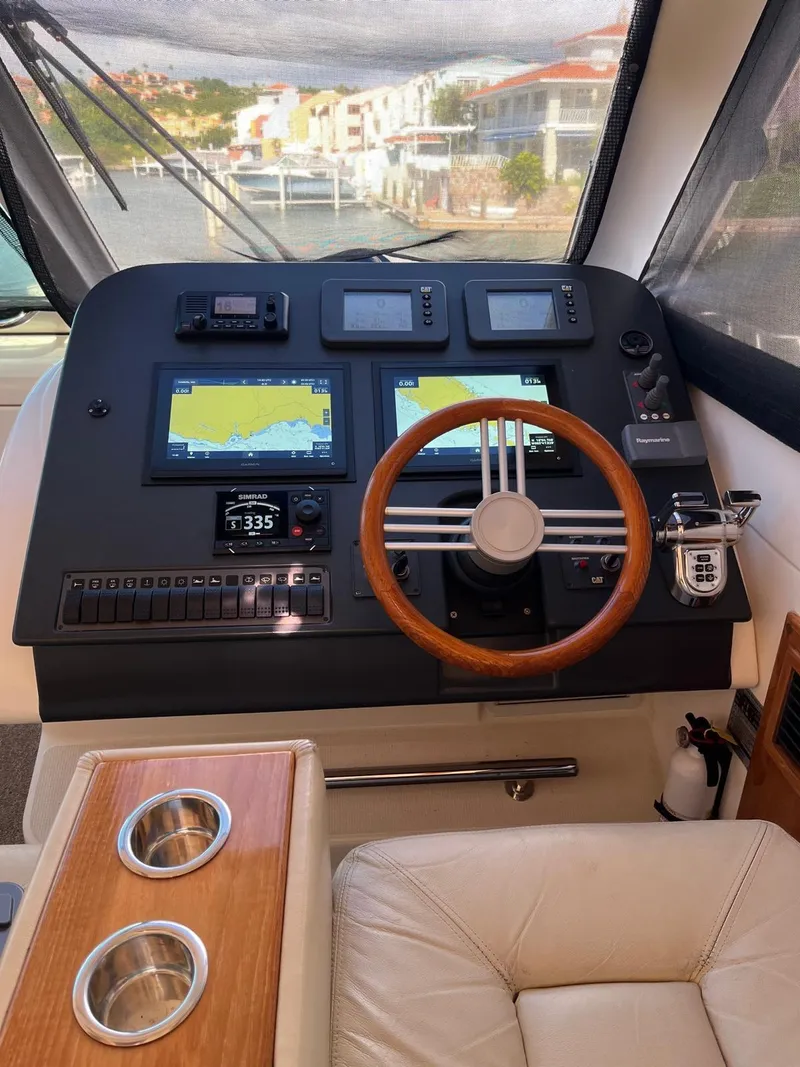 Slide: The Image of 2007 Maritimo M60 helm with navigation screens and wooden steering wheel. - 9