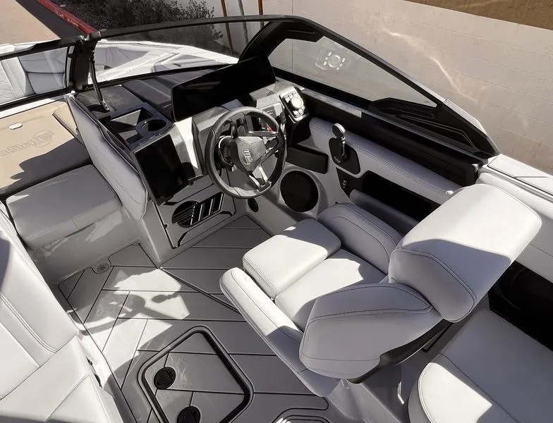 Slide: The Image of 2025 Malibu 23 LSV boat interior with sleek white seating and modern dashboard design. - 13