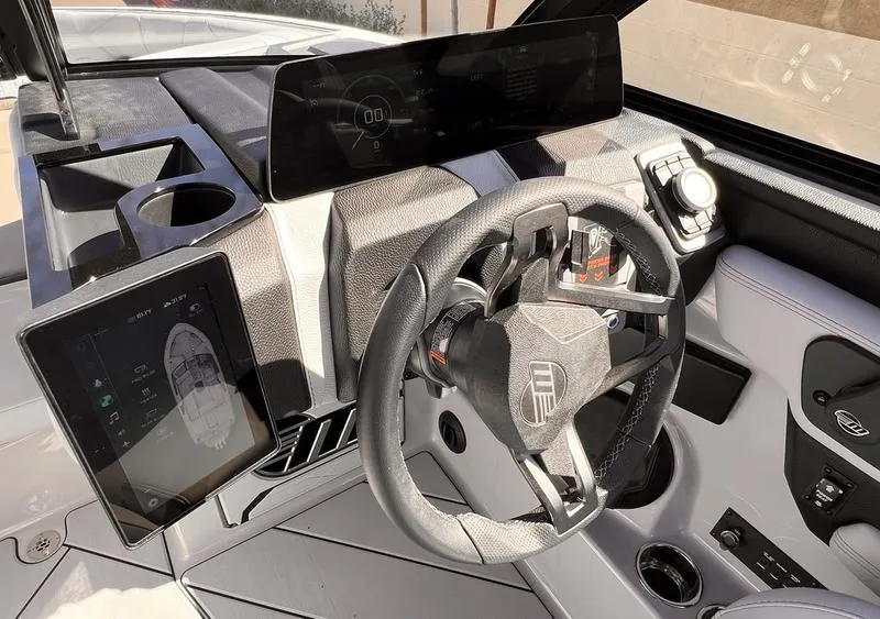 Slide: The Image of 2025 Malibu 23 LSV boat dashboard with modern steering and digital displays. - 14
