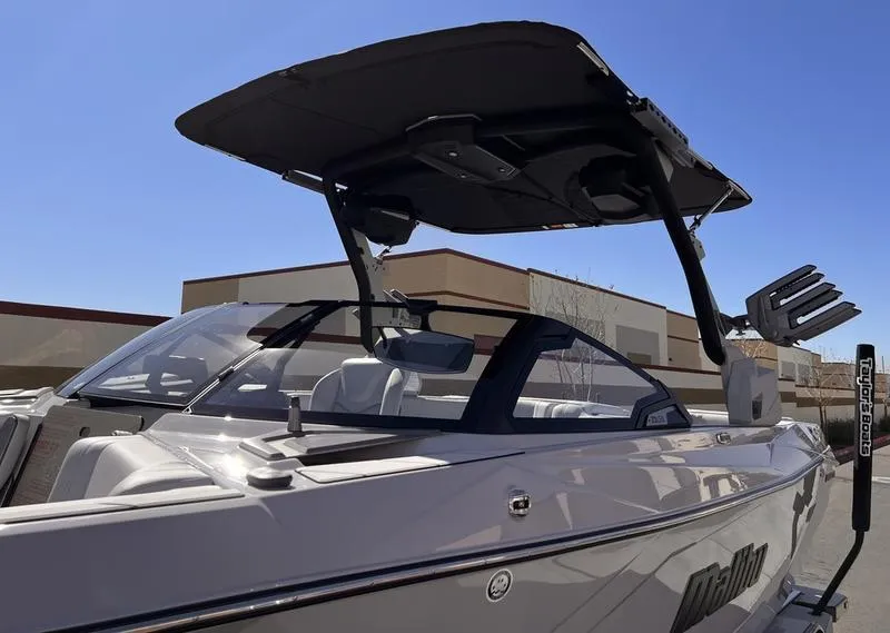 Slide: The Image of 2025 Malibu 23 LSV boat with sleek design and modern features, docked outdoors. - 8
