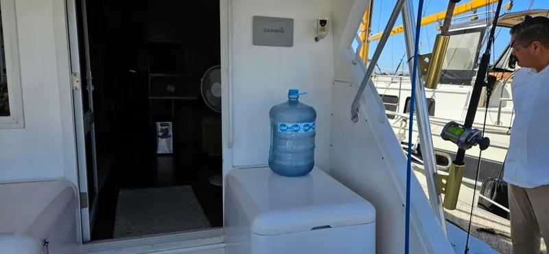 Slide: The Image of 1995 Bertram Convertible yacht interior with water jug and fishing gear. - 10