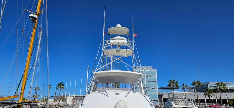 Slide: The Image of 1995 Bertram Convertible yacht docked under clear blue sky. - 14