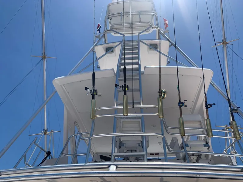 Slide: The Image of 1995 Bertram Convertible yacht tower with fishing rods against clear blue sky. - 15
