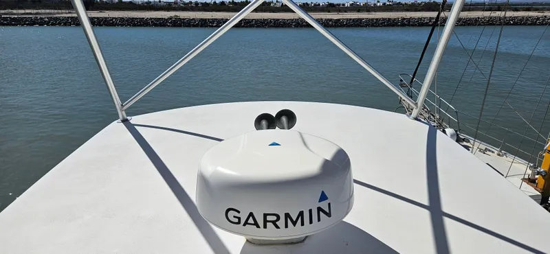 Slide: The Image of 1995 Bertram Convertible boat with Garmin radar on deck, near calm waters. - 17