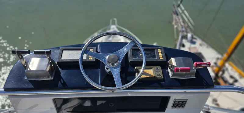 Slide: The Image of 1995 Bertram Convertible yacht helm with steering wheel and controls, overlooking water. - 18