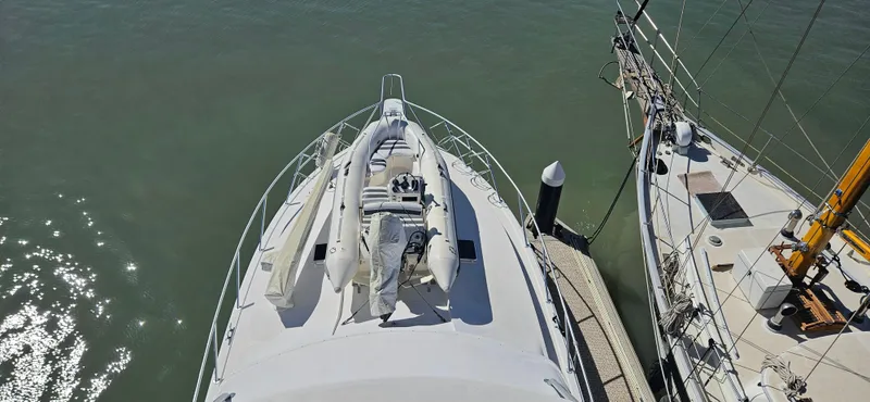 Slide: The Image of 1995 Bertram Convertible yacht docked, aerial view of bow with inflatable boat. - 19