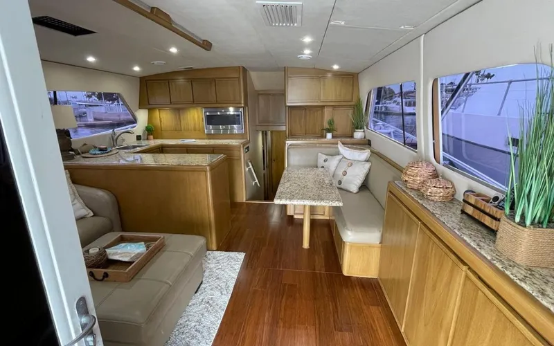Slide: The Image of Luxurious interior of a 1995 Bertram Convertible yacht with modern kitchen and seating area. - 27