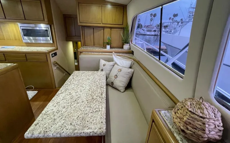 Slide: The Image of Interior of a 1995 Bertram Convertible yacht with granite table and cozy seating. - 28