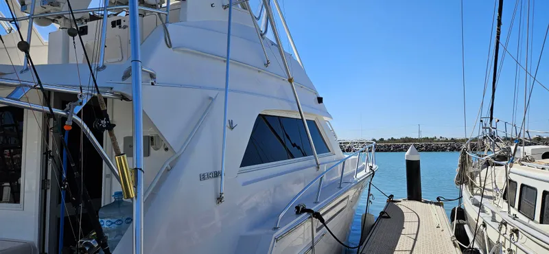 Slide: The Image of 1995 Bertram Convertible yacht docked at marina under clear blue sky. - 3
