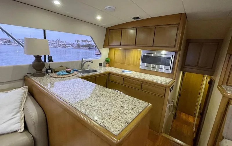 Slide: The Image of Interior of a 1995 Bertram Convertible yacht with a modern kitchen and granite countertops. - 33
