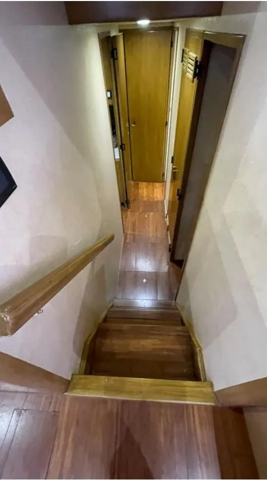 Slide: The Image of Interior view of 1995 Bertram Convertible yacht, featuring wooden stairs and hallway. - 37