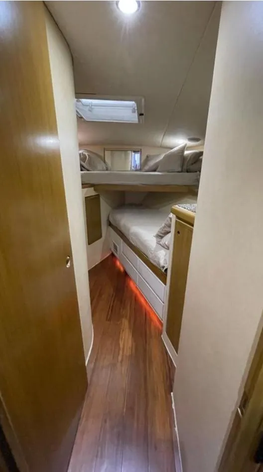 Slide: The Image of 1995 Bertram Convertible yacht interior with wooden flooring and cozy sleeping quarters. - 38