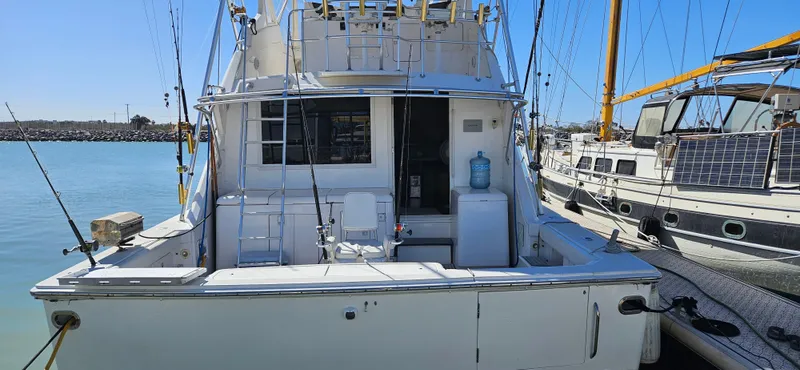 Slide: The Image of 1995 Bertram Convertible yacht docked at marina, rear view with fishing equipment. - 4