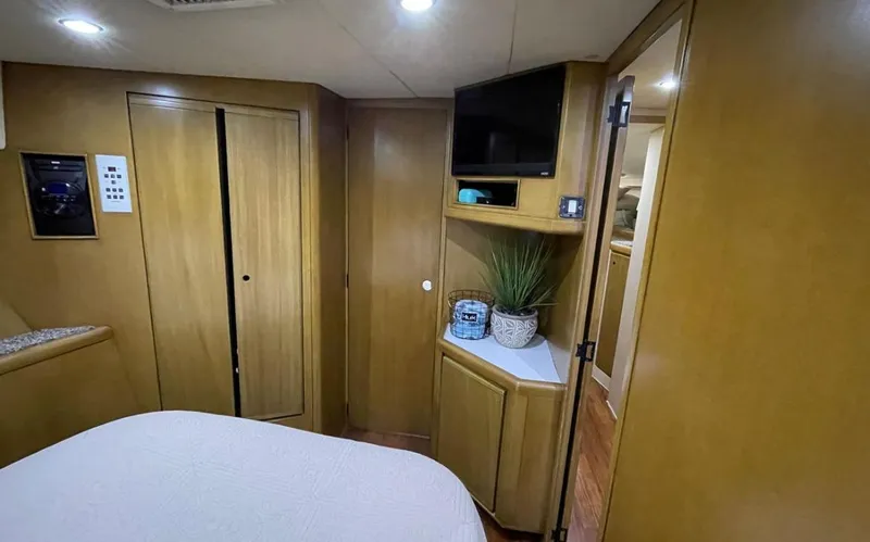 Slide: The Image of 1995 Bertram Convertible yacht interior with wood paneling, TV, and cozy decor. - 45