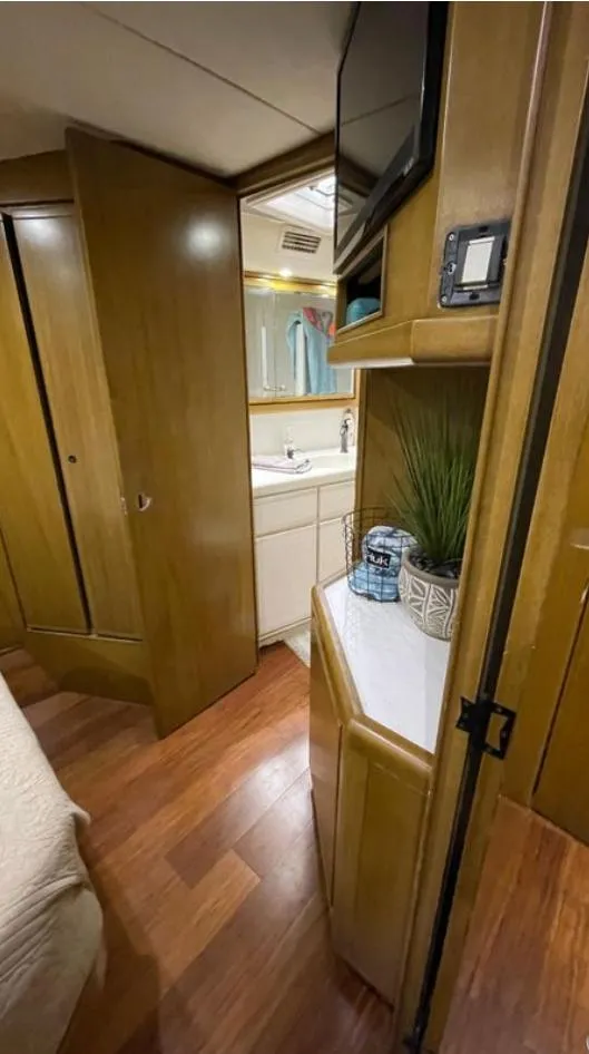Slide: The Image of Interior of a 1995 Bertram Convertible yacht with wood paneling and compact bathroom. - 46