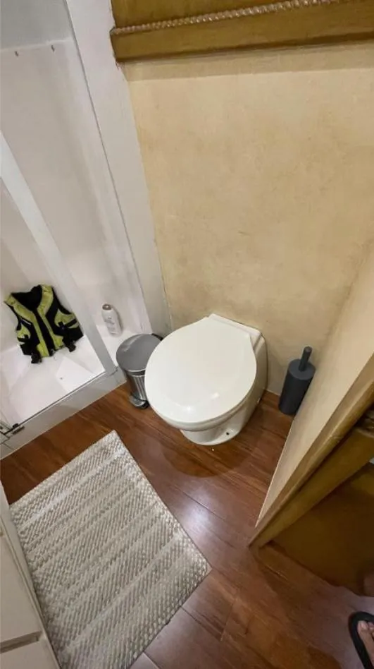 Slide: The Image of Bathroom interior of a 1995 Bertram Convertible yacht with wooden flooring. - 48