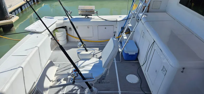 Slide: The Image of 1995 Bertram Convertible boat deck with fishing rods and seating. - 6